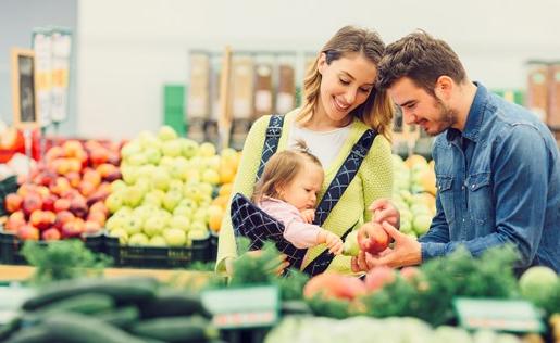 A family of three in the produce section of a grocery