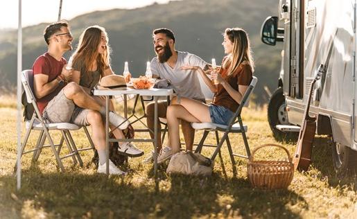 Friends eating outside by an RV